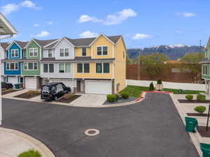View of front of home featuring a residential view, a garage, board and batten siding, concrete driveway, and a mountain view
