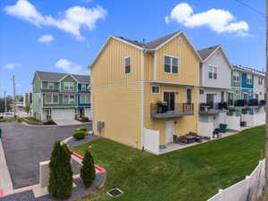 Rear view of property with a residential view, board and batten siding, a patio area, and a balcony