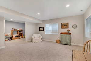 Sitting room with light colored carpet and recessed lighting