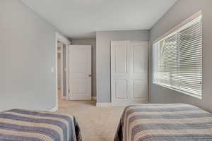 Bedroom featuring light colored carpet and baseboards