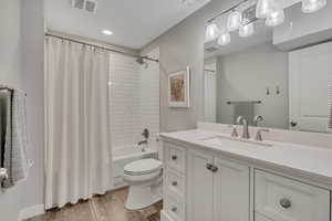 Full bathroom with vanity, light wood finished floors, and shower / tub combo