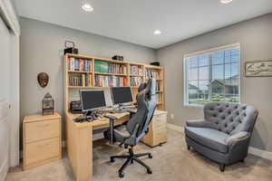 Home office with recessed lighting and light carpet