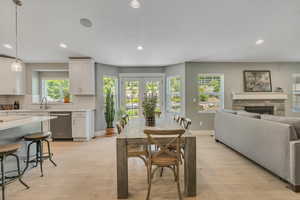 Dining room featuring a fireplace, recessed lighting, and light wood finished floors