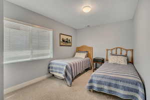 Bedroom with baseboards and light carpet