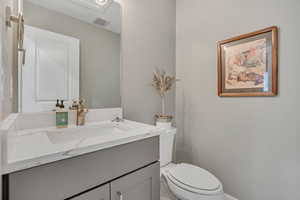 Half bathroom featuring vanity and toilet