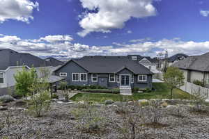 Back of house featuring a shingled roof and a residential view