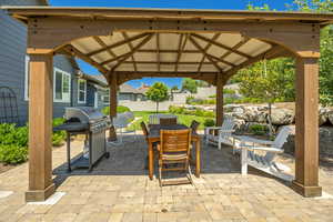 View of patio / terrace featuring a gazebo, outdoor dining area, a grill, and a residential view