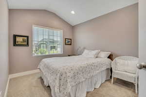 Bedroom with lofted ceiling, light carpet, and recessed lighting