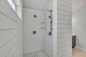 Bathroom featuring vanity, a stall shower, and light tile patterned flooring