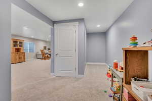 Recreation room featuring light colored carpet and recessed lighting