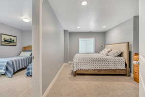 Bedroom with light carpet and recessed lighting