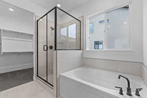Full bathroom with a garden tub, a shower stall, and a walk in closet