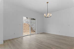 Unfurnished dining area with a chandelier and light wood-type flooring