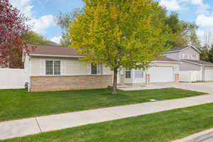 View of front of property with brick siding, driveway, a garage, and a shingled roof