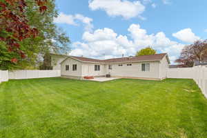 Rear view of house featuring a patio area and a fenced backyard