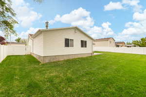 Rear view of house with a fenced backyard and a gate