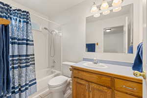 Bathroom featuring vanity, shower / tub combo with curtain, and light tile patterned flooring