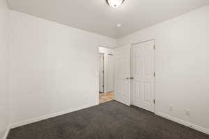 Unfurnished bedroom featuring carpet, a textured ceiling, and a closet