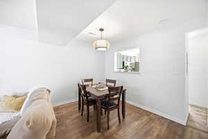 Dining room with crown molding, wood finished floors, and a textured ceiling
