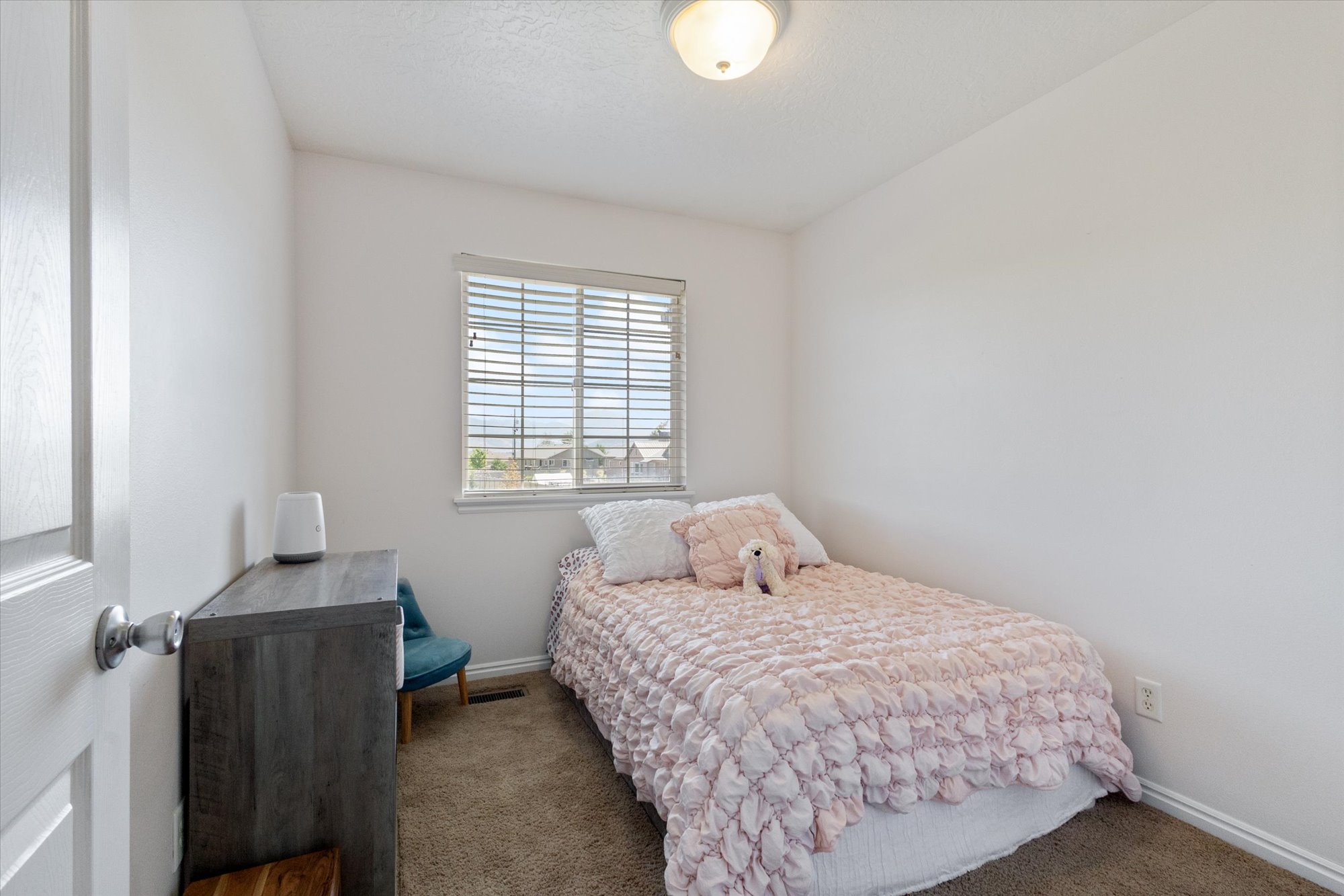 Bedroom with dark colored carpet and baseboards