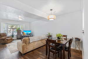 Dining room with wood finished floors, ornamental molding, and a textured ceiling