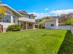 Fenced backyard featuring a patio area, an outdoor structure, and a mountain view