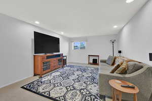 Living area featuring light colored carpet and recessed lighting