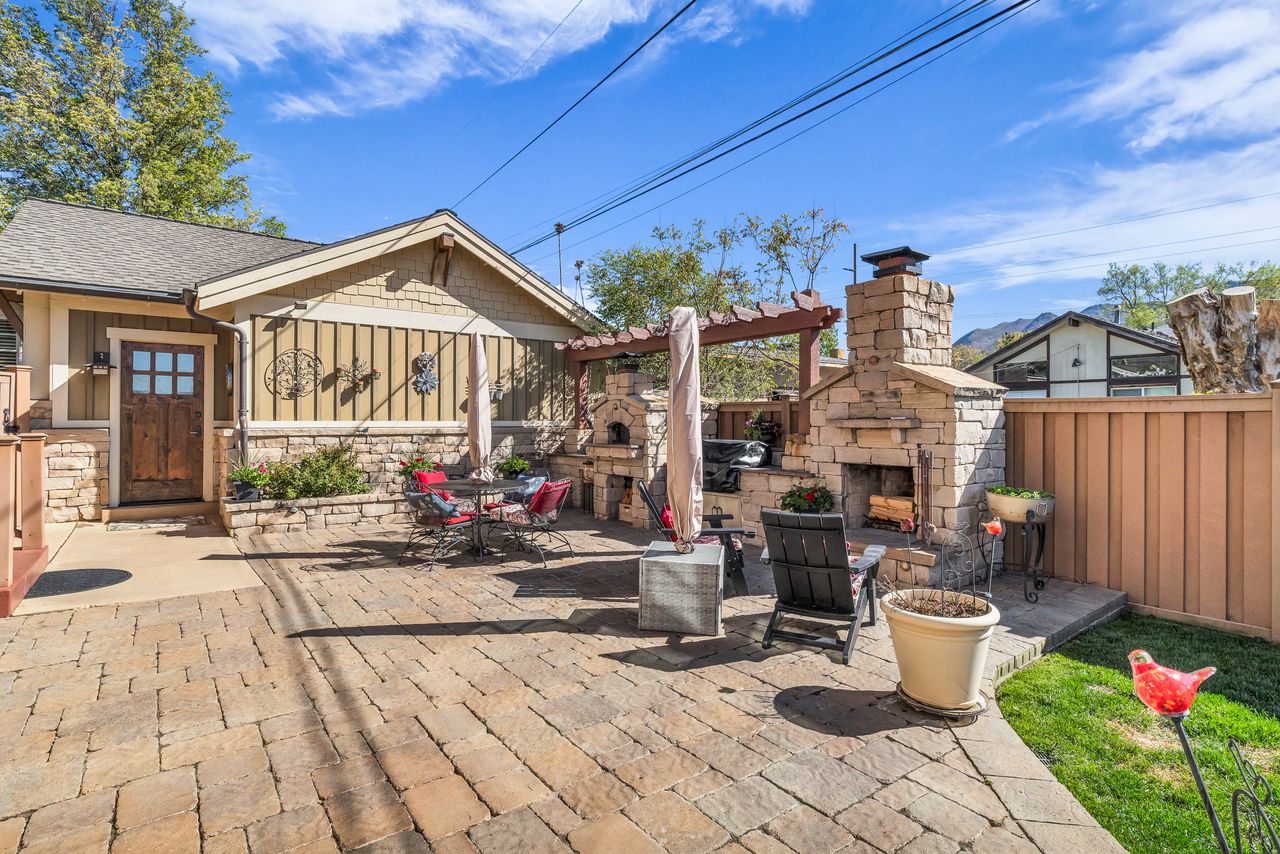 View of patio / terrace with an outdoor stone fireplace, a pergola, and outdoor dining area