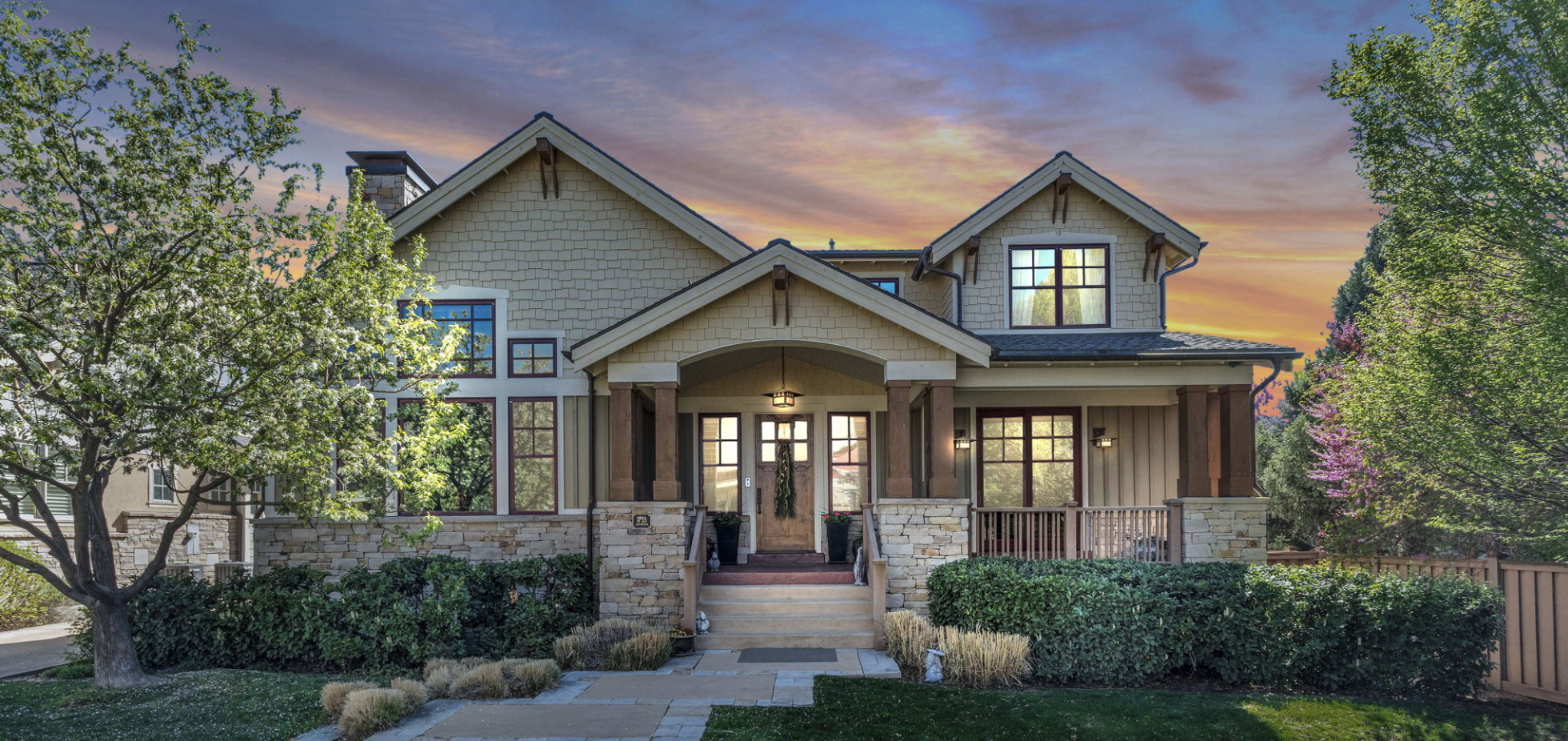 Craftsman house with stone siding, a porch, board and batten siding, and a chimney