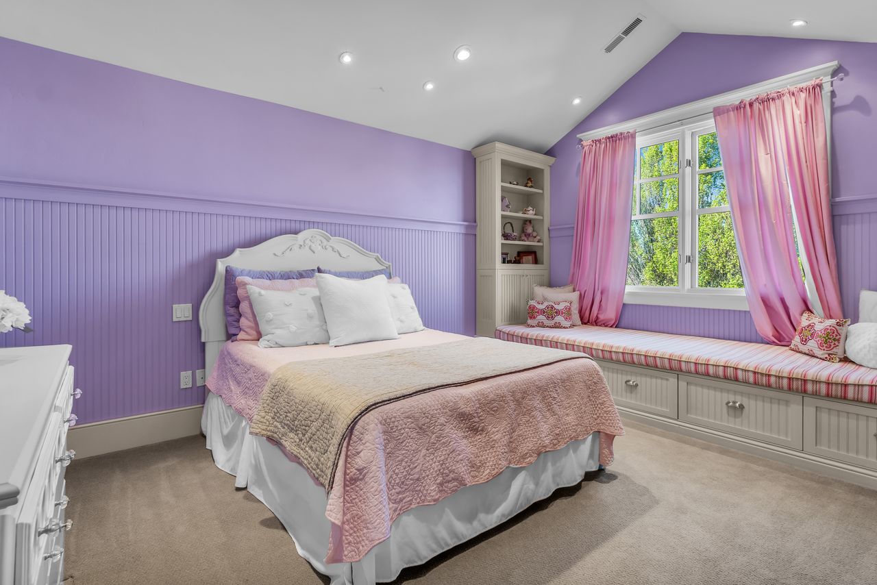 Child's bedroom with a wainscoted wall, lofted ceiling, light carpet, and recessed lighting