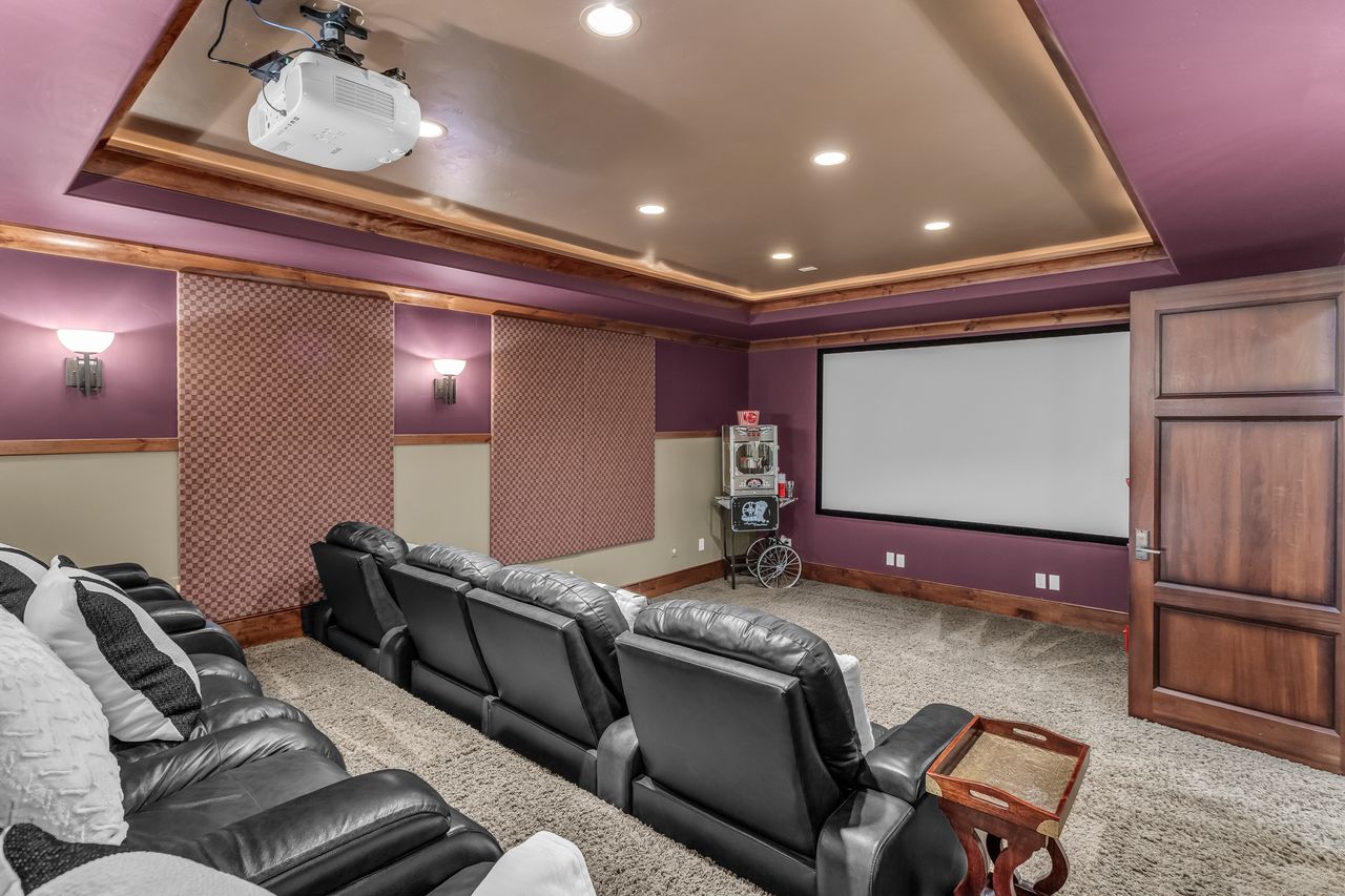 Cinema room with a tray ceiling, light carpet, and recessed lighting