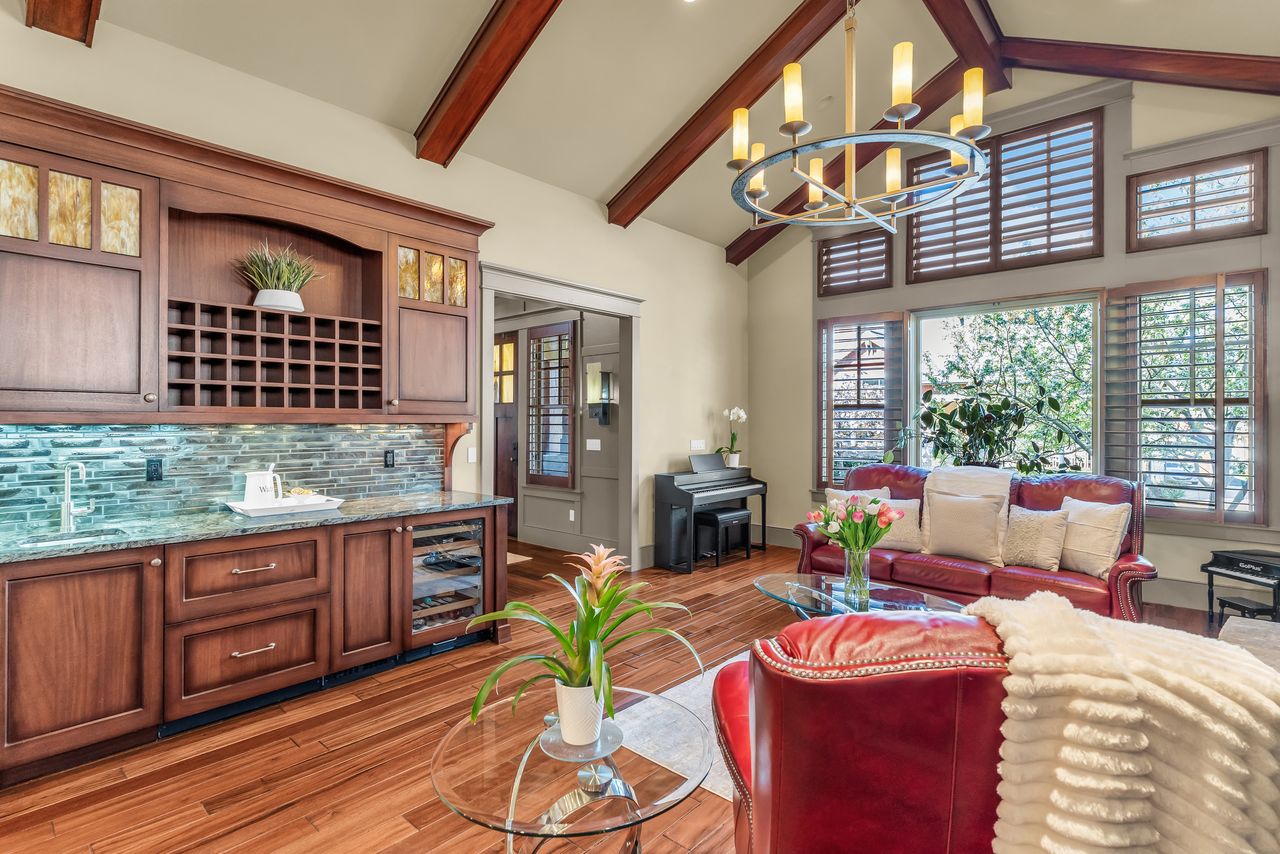 Living room featuring lofted ceiling, light wood flooring, wine cooler, and dry bar