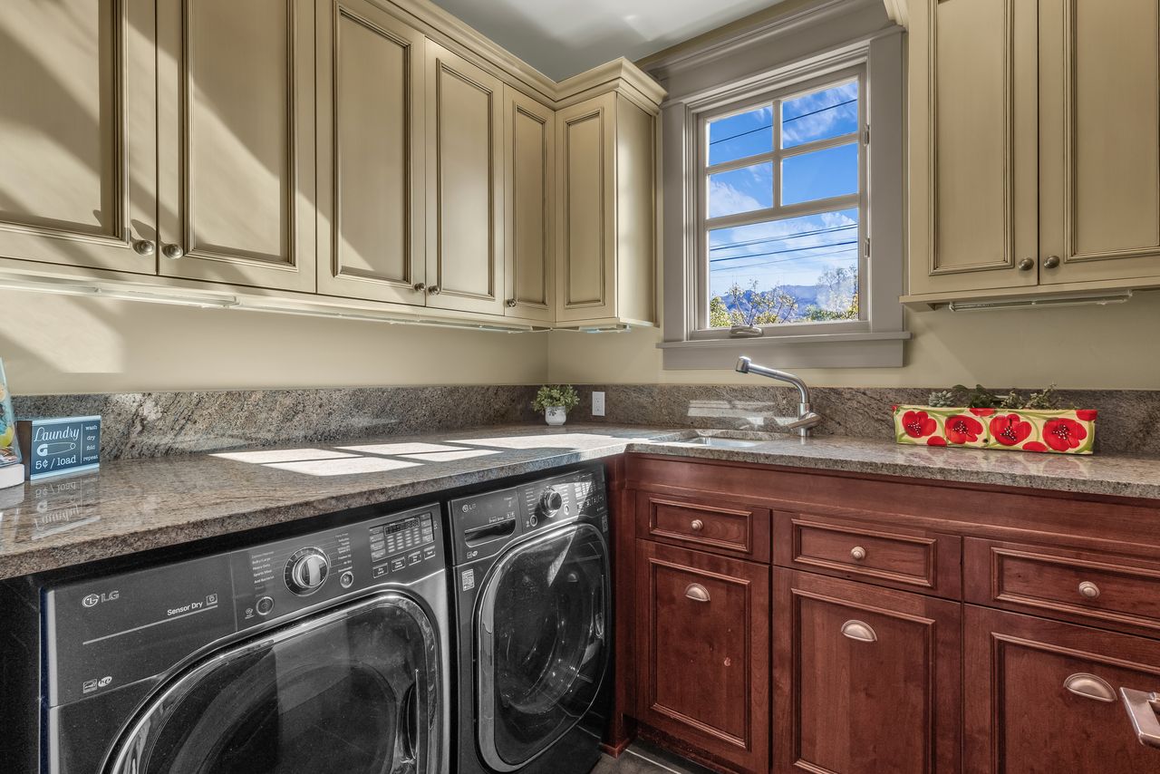 Main floor laundry area with washer and dryer and cabinet space