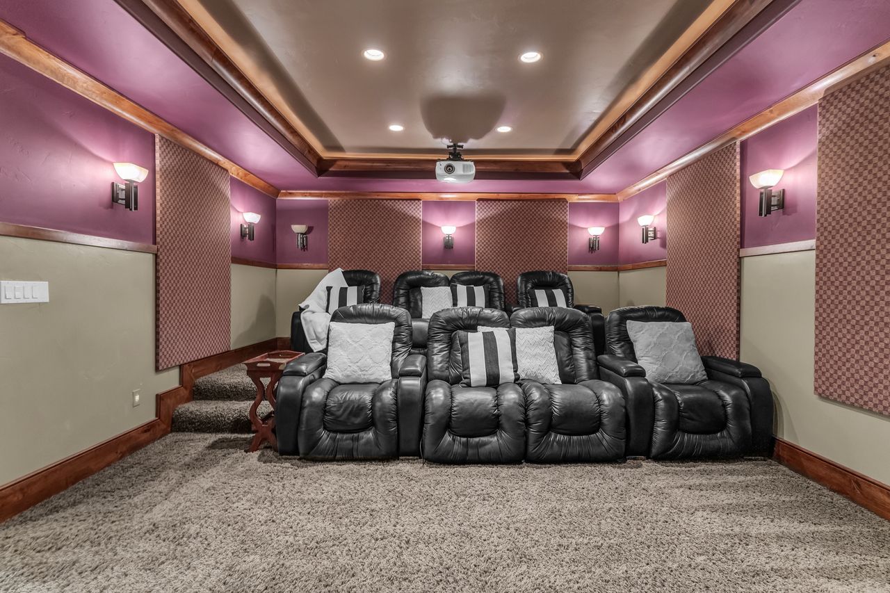 Carpeted home theater featuring a raised ceiling and recessed lighting