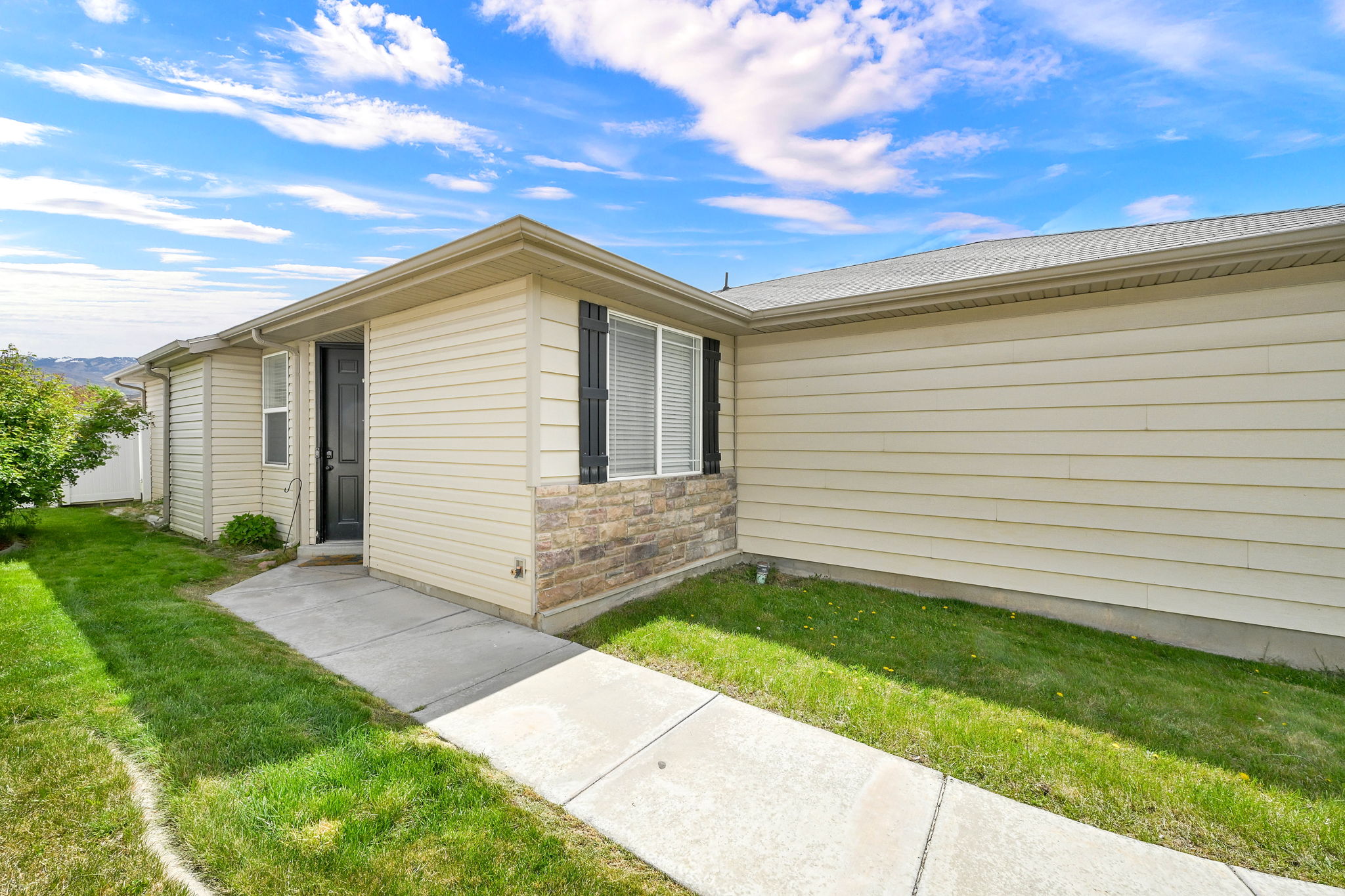 Entrance to property with a yard and stone siding