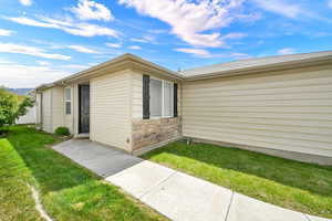 Entrance to property with a yard and stone siding