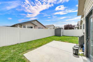 Fenced backyard featuring a patio area and a gate