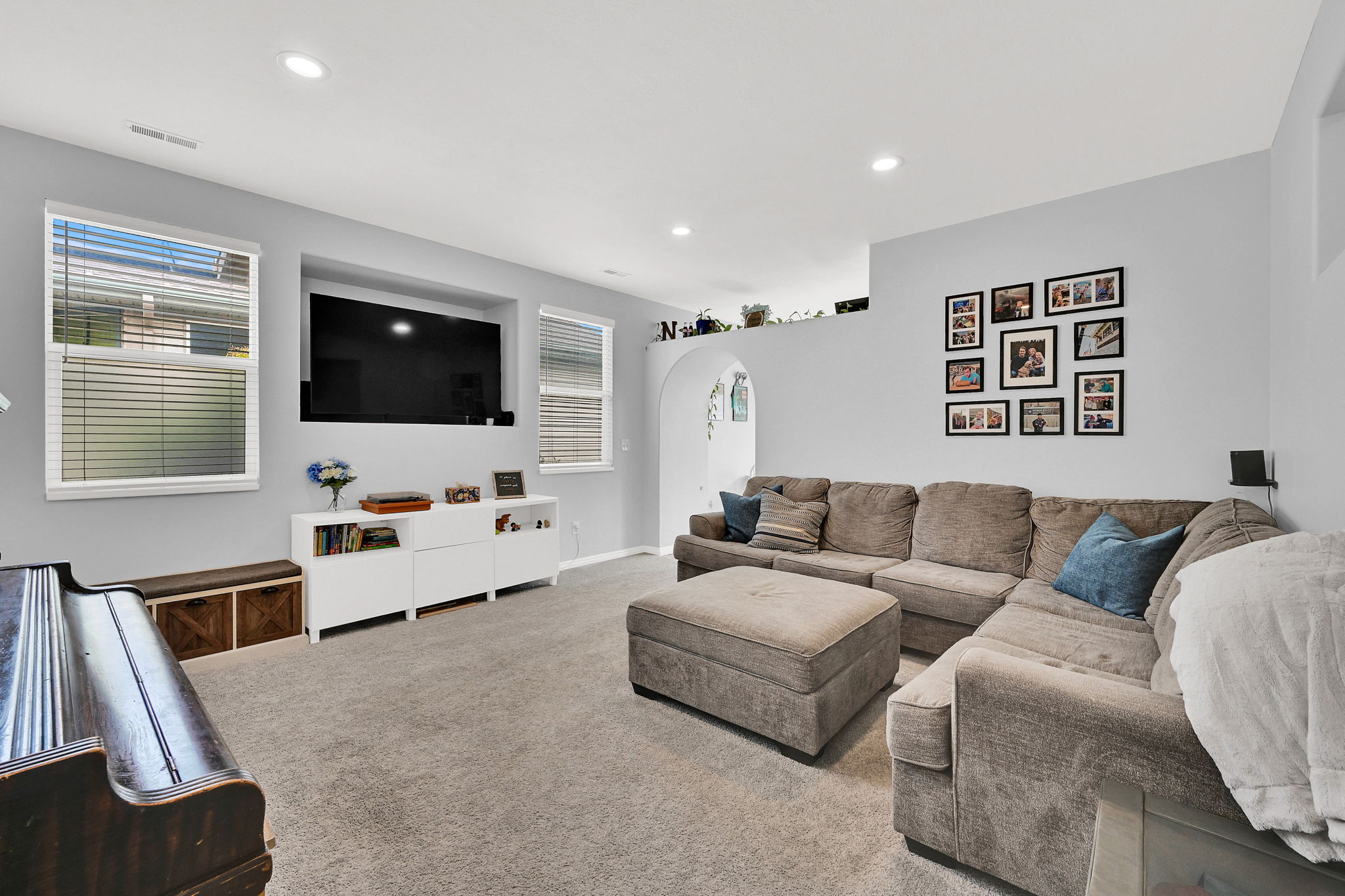 Living area featuring arched walkways, carpet flooring, and recessed lighting