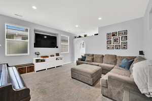 Living area featuring arched walkways, carpet flooring, and recessed lighting