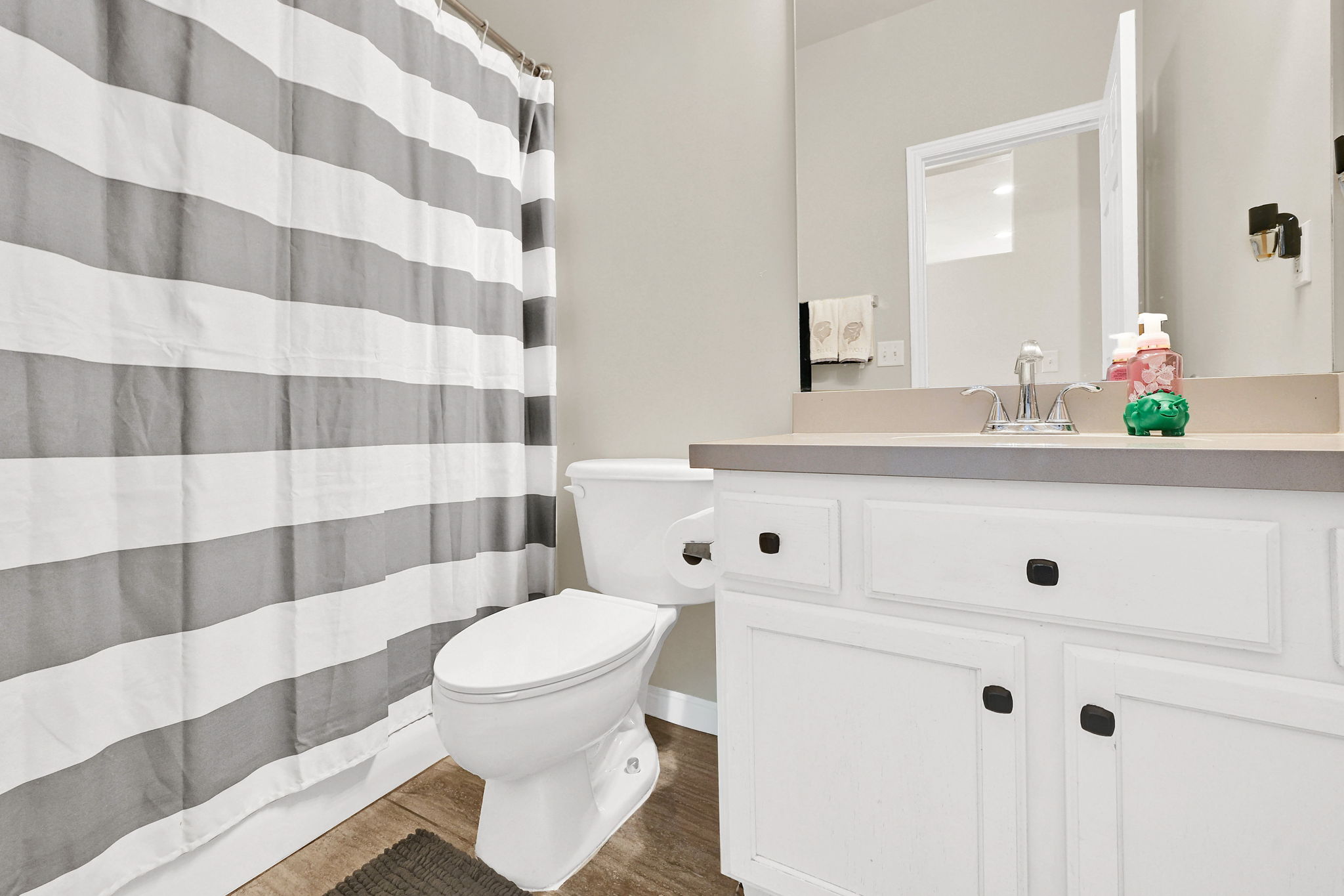 Full bath with curtained shower, vanity, and dark wood-style floors