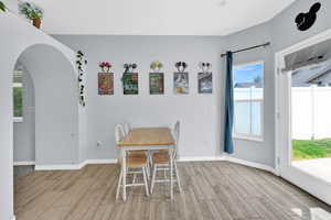 Dining room featuring wood finish floors and arched walkways