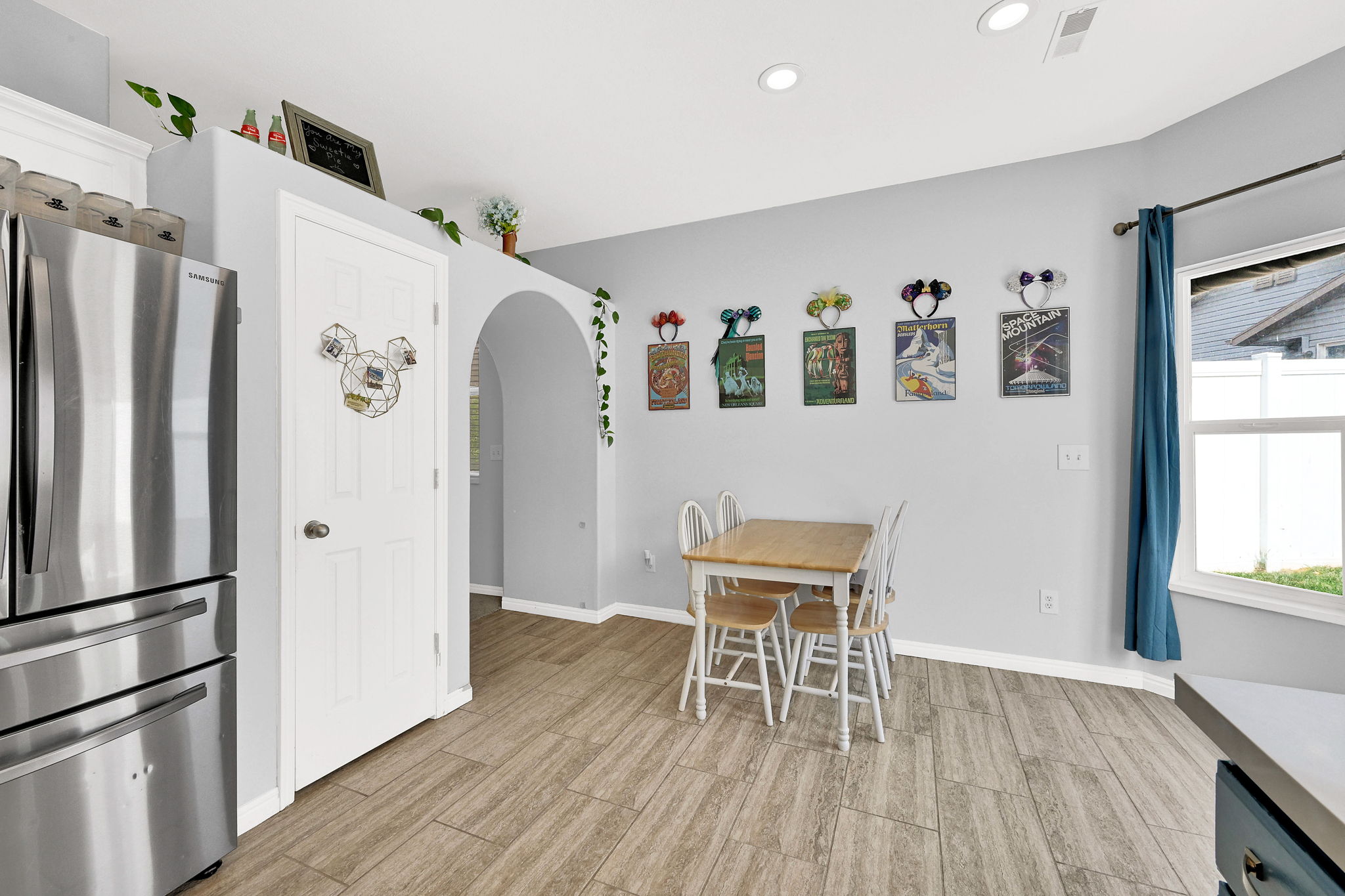 Dining area with arched walkways, wood finish floors, and recessed lighting