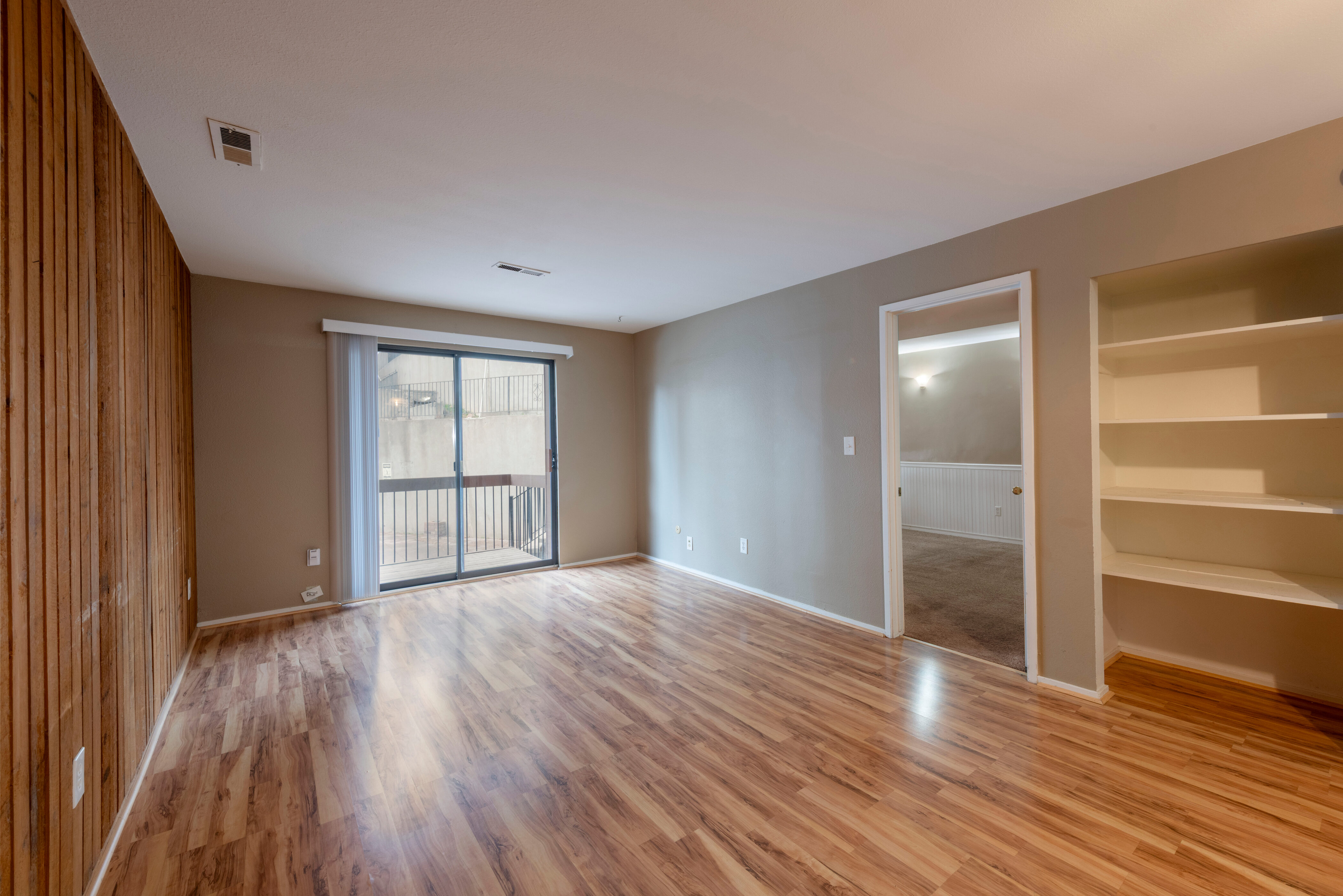 Living area without furniture,&  light wood-type flooring