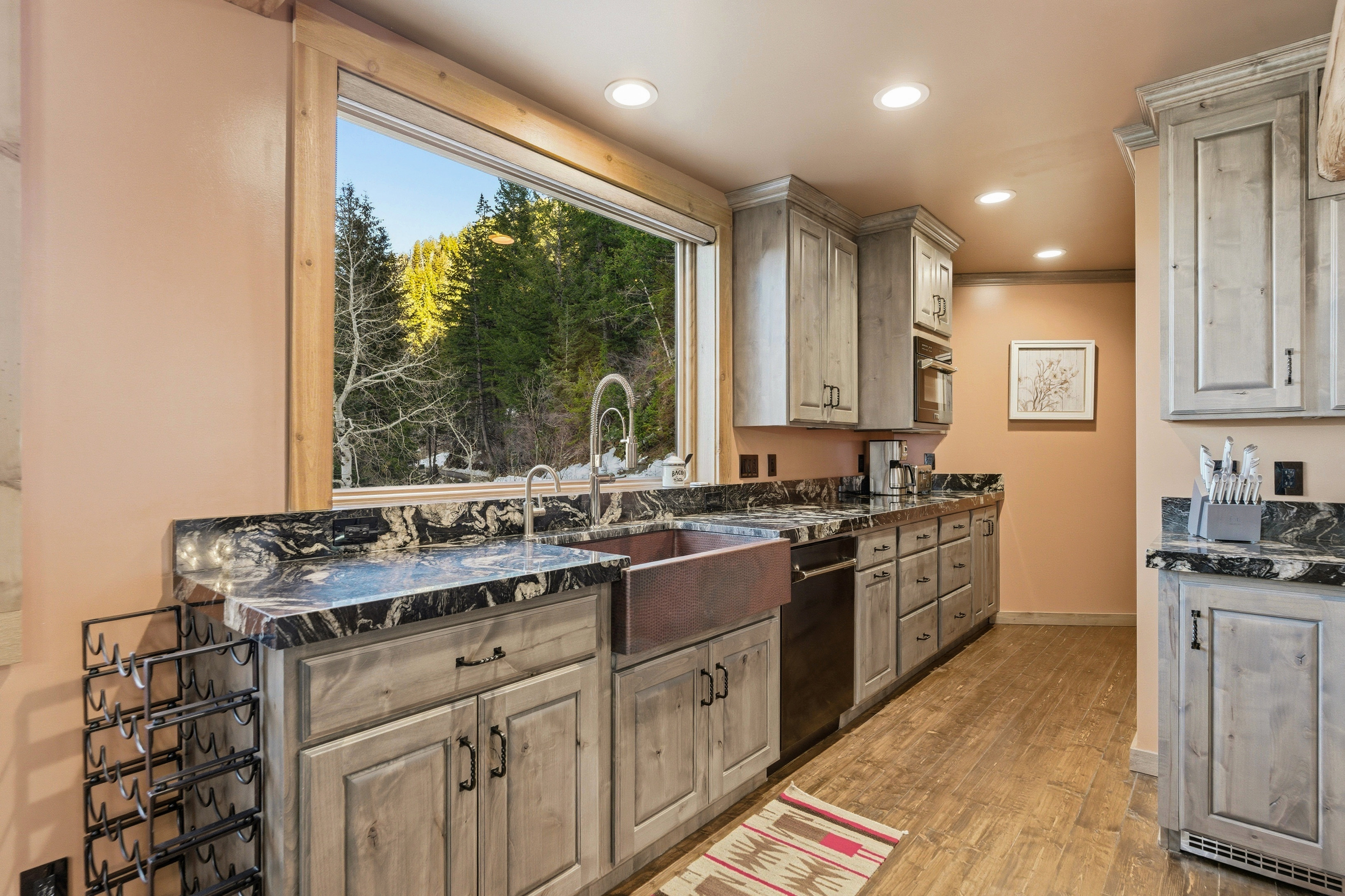 Kitchen with dark stone counters, recessed lighting, light wood-style flooring, crown molding, and black dishwasher