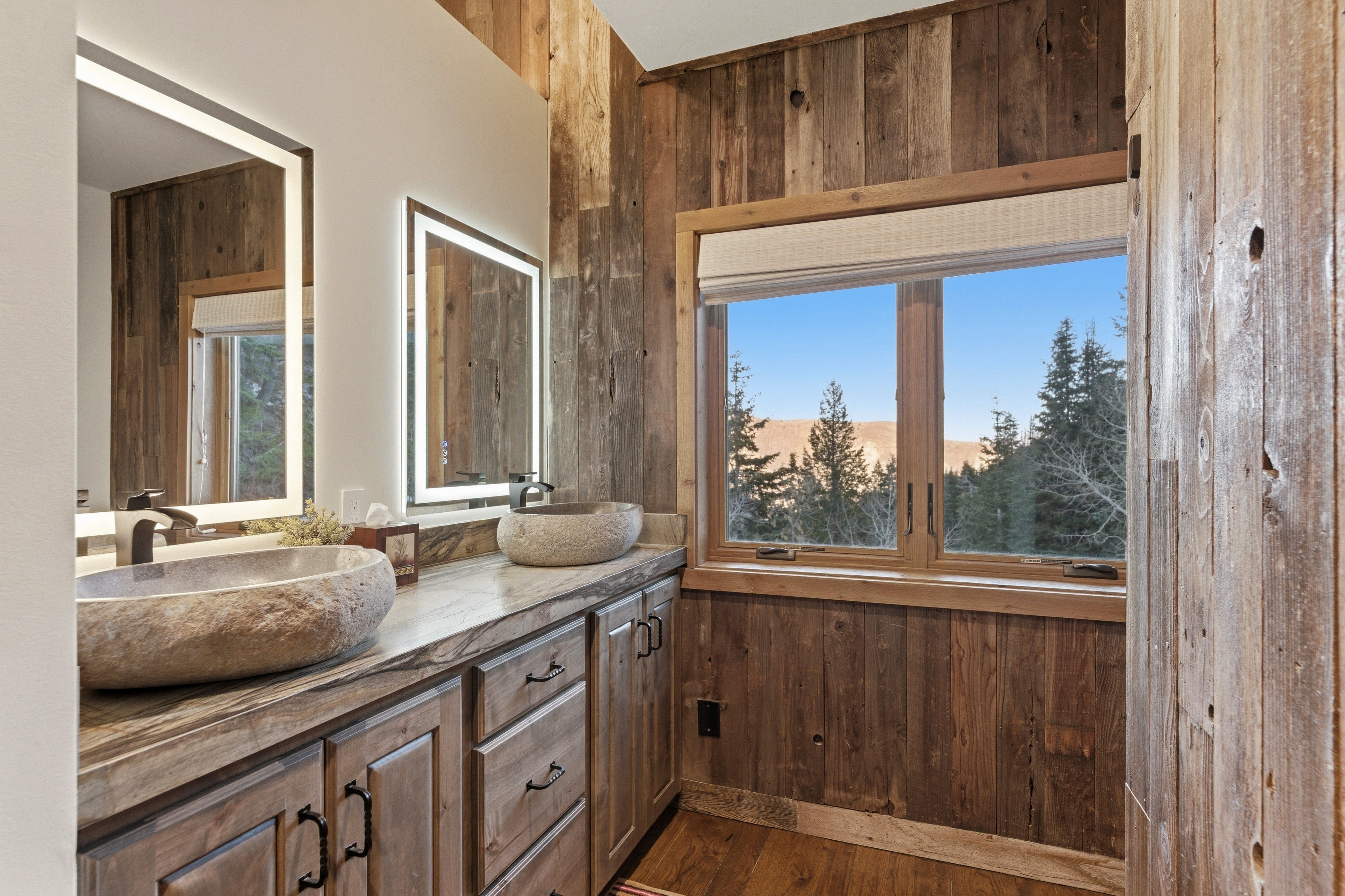 Full bathroom with wooden walls, double vanity, and dark wood-style floors