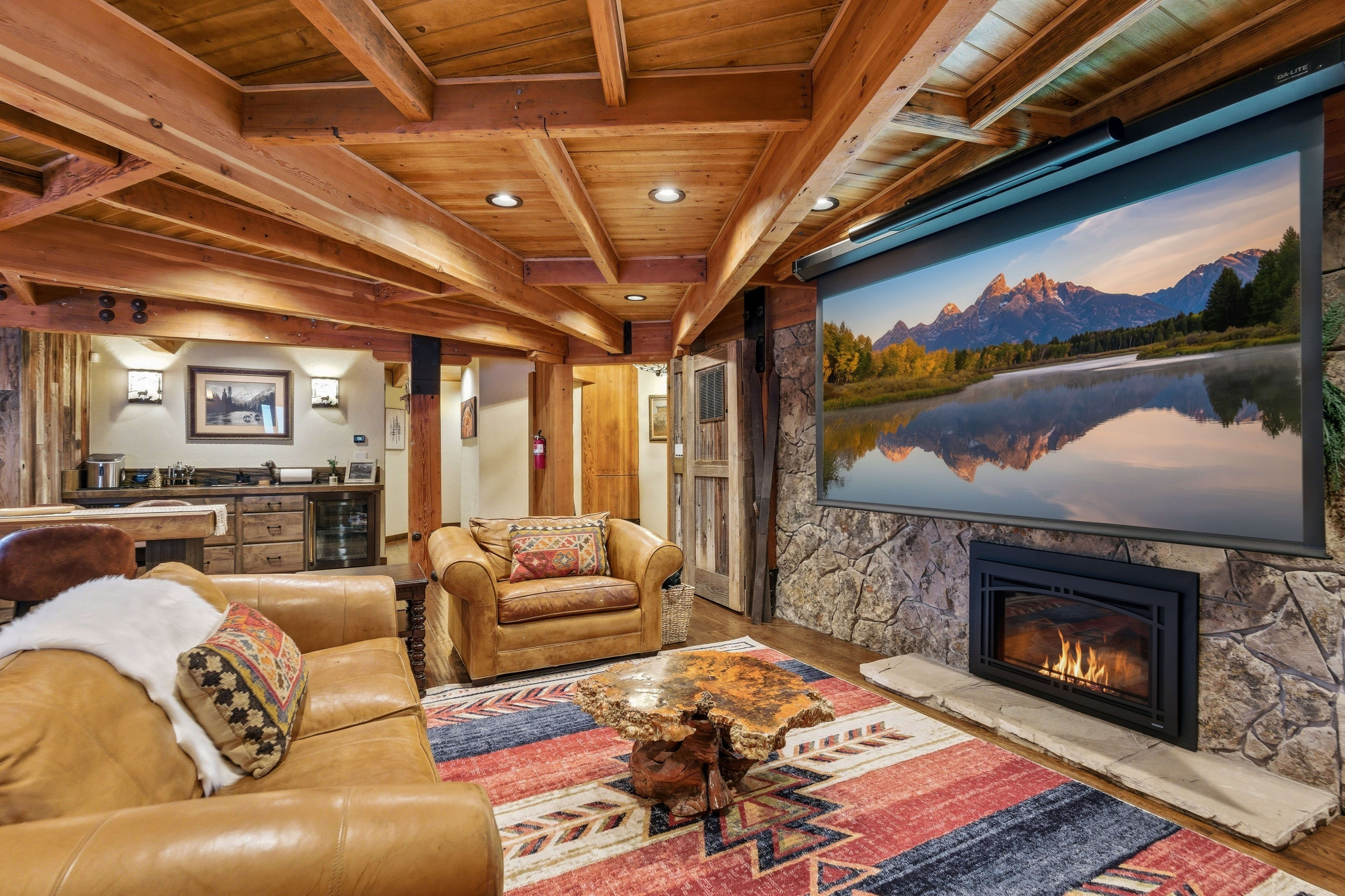 Home theater featuring a wooden ceiling with exposed beams, recessed lighting, wood finished floors, beverage cooler, and a stone fireplace