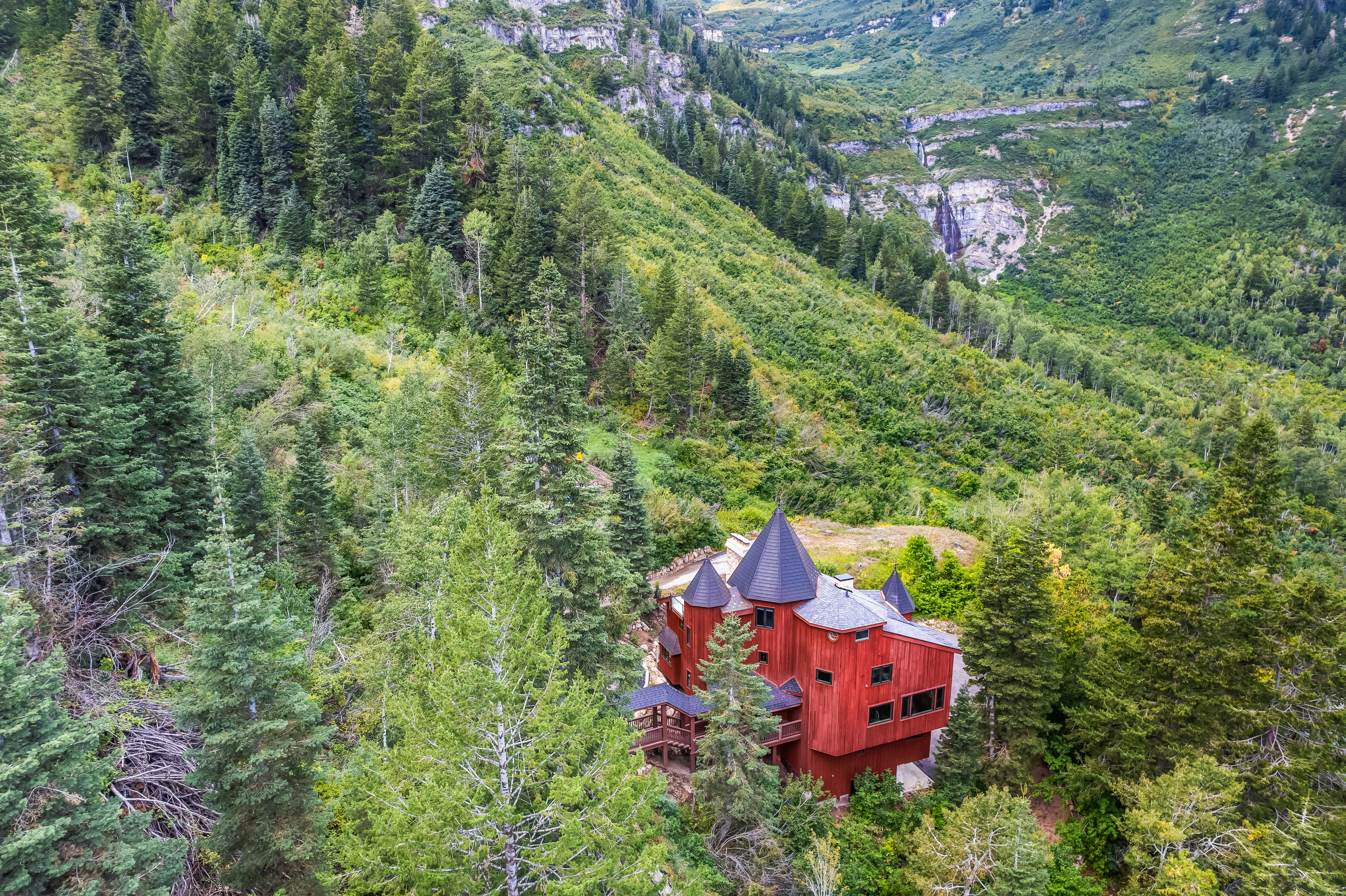 Aerial view of property and surrounding area featuring a forest