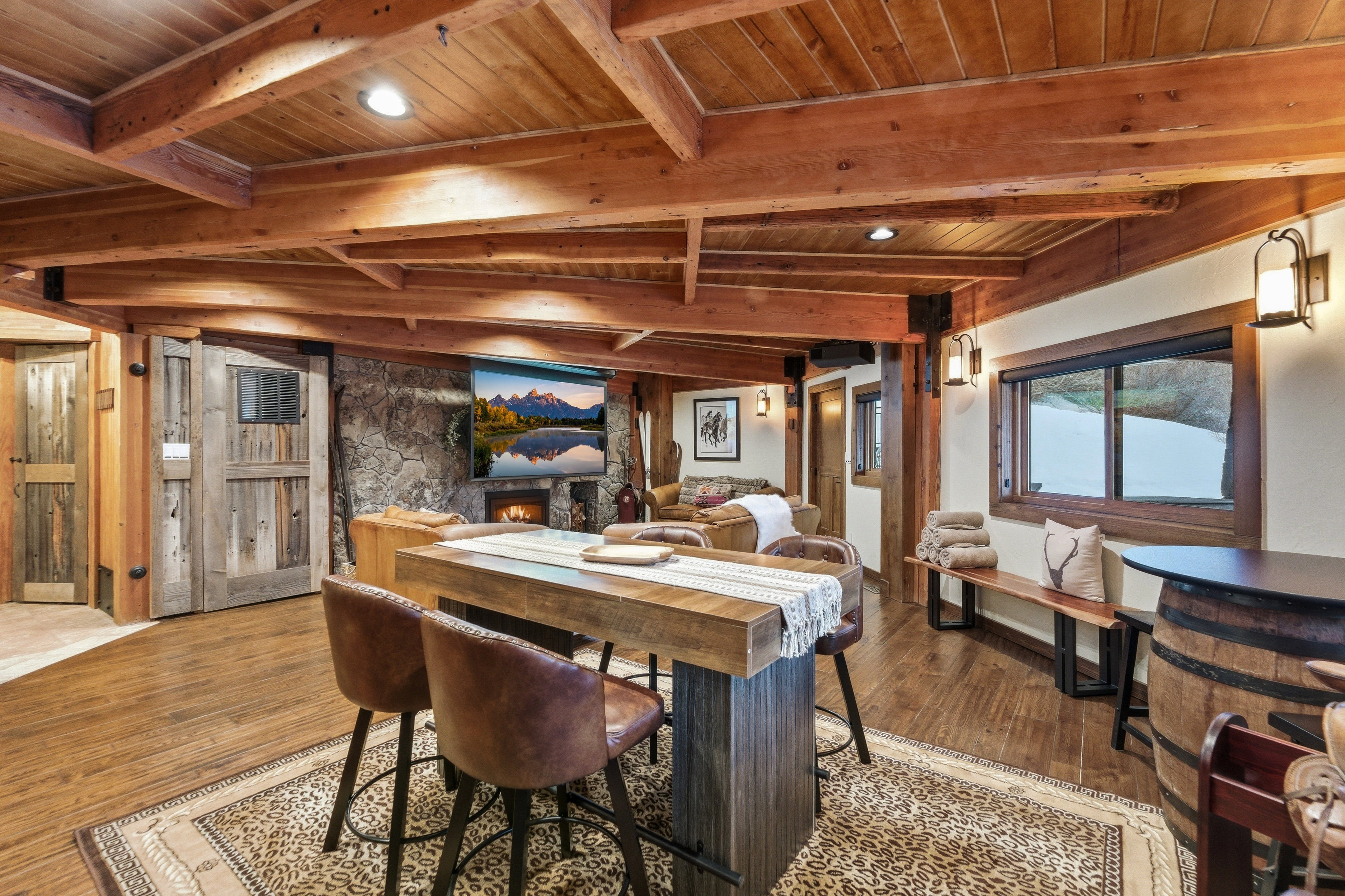 Dining room with a wood ceiling with exposed beams, a stone fireplace, wood finished floors, and recessed lighting