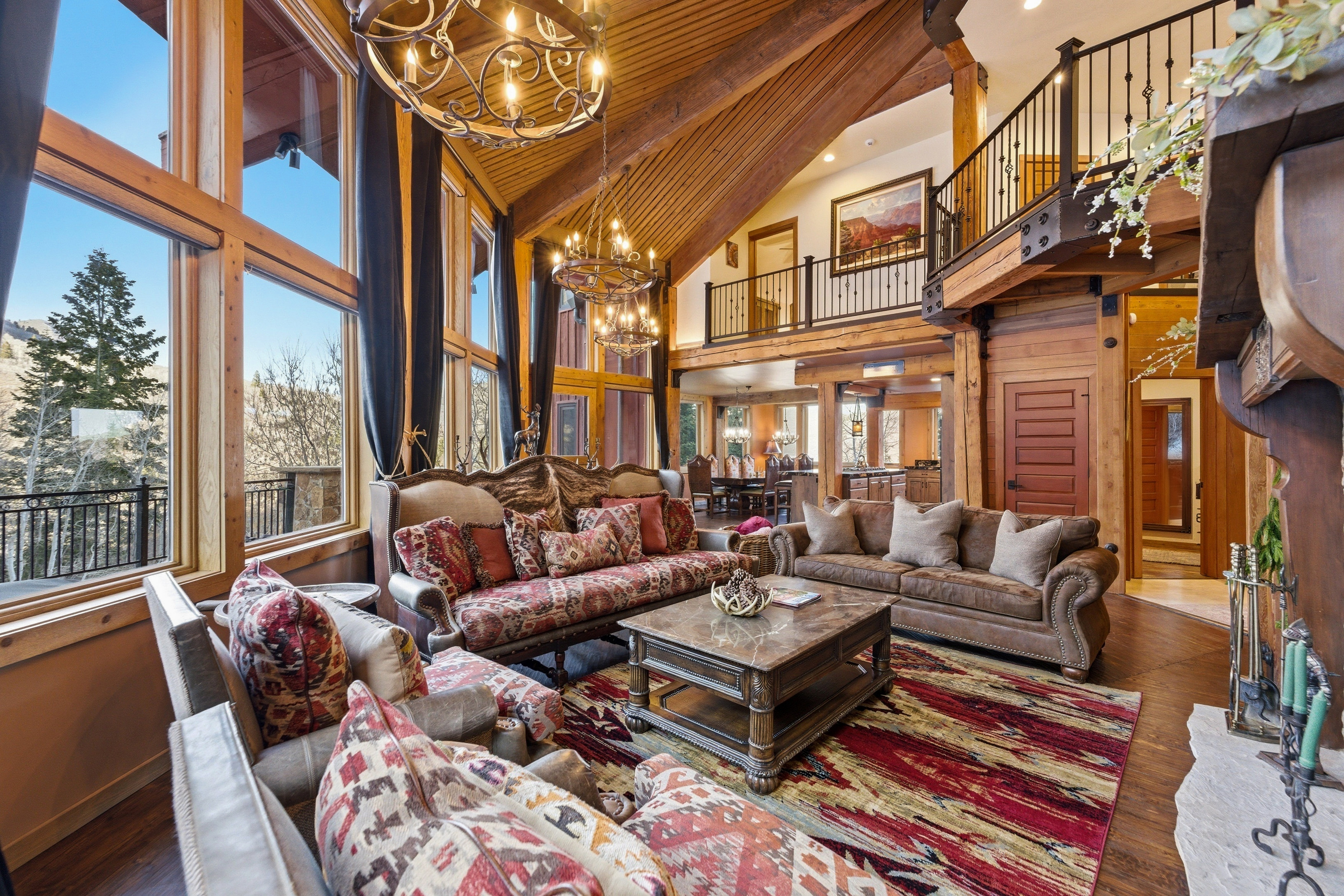 Living area featuring a chandelier, wood walls, dark wood-style floors, and a high wood beamed ceiling