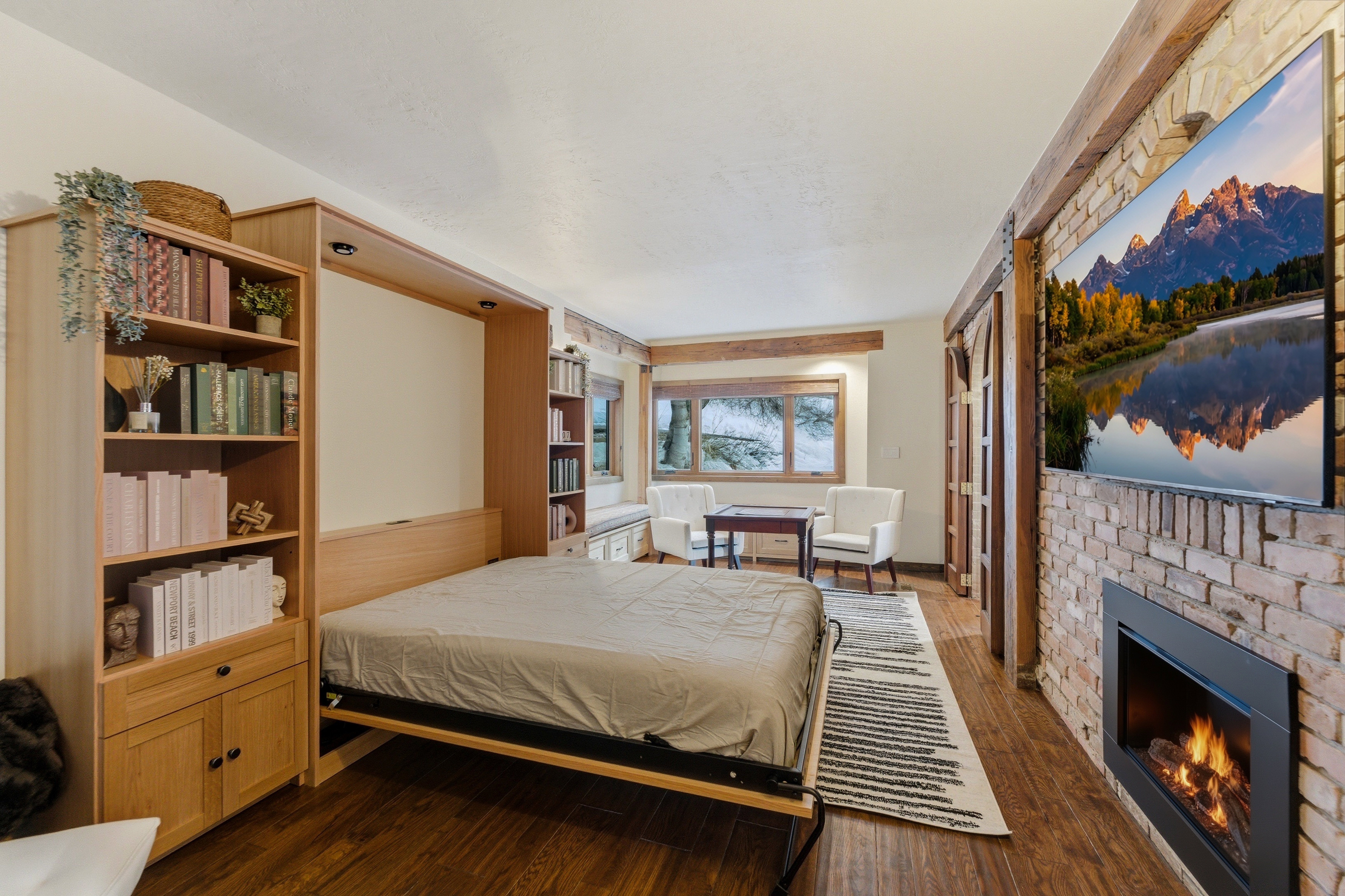 Bedroom with a brick fireplace and dark wood-type flooring